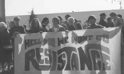 Protesters hold up banner that reads, Hell No We Won’t Go, Resistance, 1968.