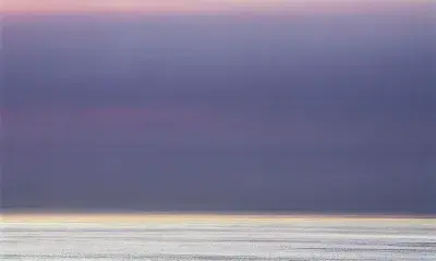 Sky at sunrise with ocean and purple clouds