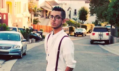 Person wearing suspenders stands in a residential street