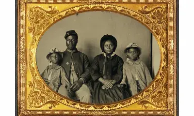 Quarter-Plate Ambrotype taken between 1863 and 1865. Image depicts a Black Union Army private and his wife and twin daughters.
