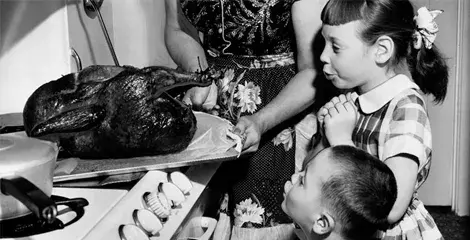 children oohing at turkey coming out of the oven