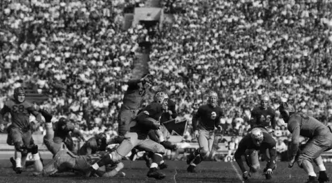 The University of California at Los Angeles after trailing California at Berkeley through the first quarter, finally came into its own at the Memorial Coliseum. In this photo, Kenny Washington, brilliant Bruin halfback, is away to a smashing gain as his teammate, Woody Strode, effectively blocks out the California secondary defense. Dated November 4, 1939