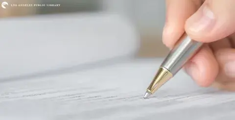 hand holding pen filling out an application