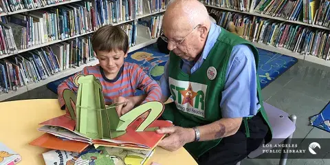 Senior reading to a child at the library