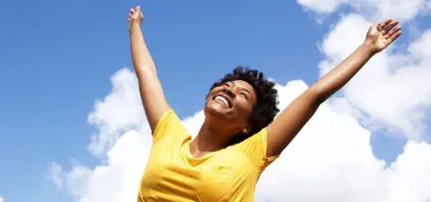 cheerful young woman with hands raised