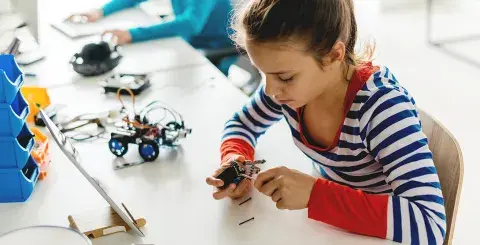 Young girl building an electronic device