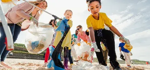 kids and parents clean up a beach