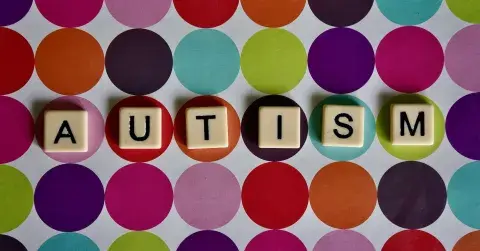Scrabble tiles spelling out the word AUTISM