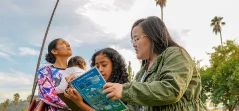 kids participating in a cloud identification class outside the library