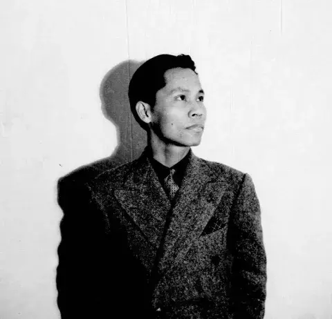 Man stands against wall with his shadow behind