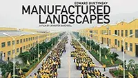 A movie poster for "Manufactured Landscapes." A crowd of people wearing yellow on a long street.