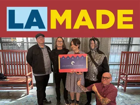 La Made banner with librarians holding a giant card