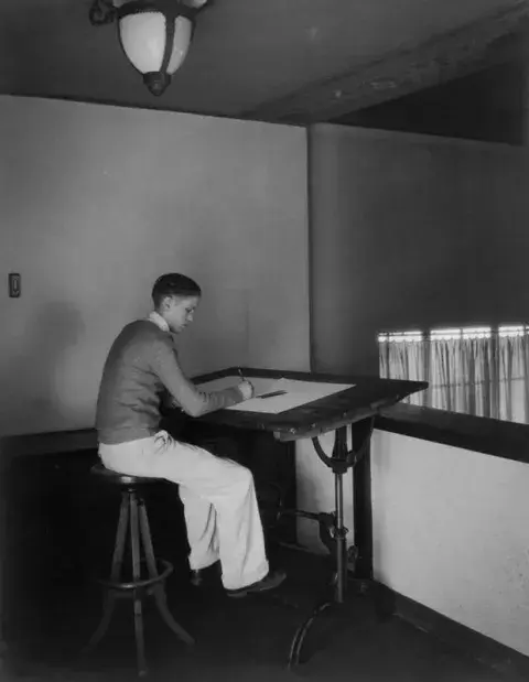 Man sitting at a drafting table available for public use 