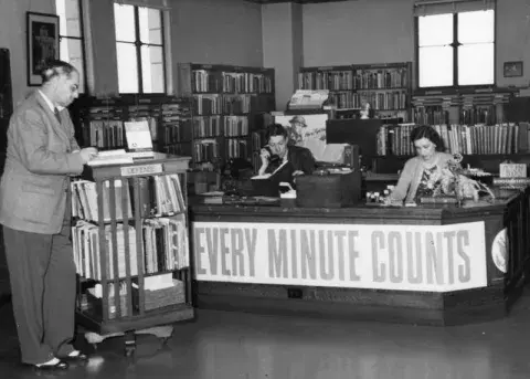 Armine Mackenzie on the telephone at the Municipal Reference Library in City Hall