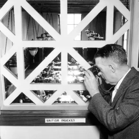 men with binoculars looking in a window