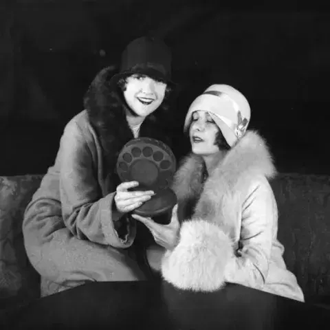 2 women holding an old fashioned microphone