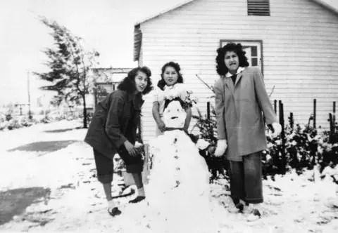 3 women with a homemade snowman