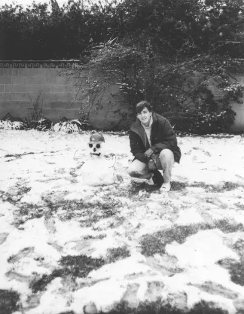 boy with a snowman wearing a Dodger cap