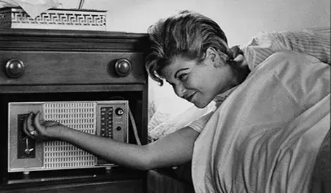 Women waking up and turning off her alarm clock