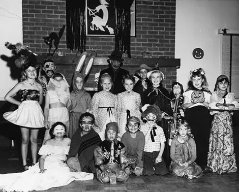 Children in costume pose at a Halloween party