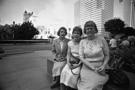 Librarians Kathleen Leidich, Helene Mochedlover, and Billie Conner sit solemnly across the street from Central Library as the fire rages