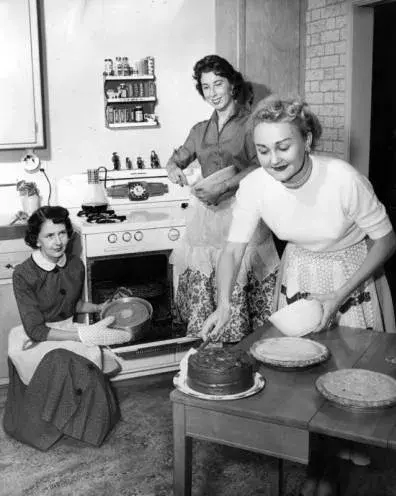 3 women cook in a kitchen