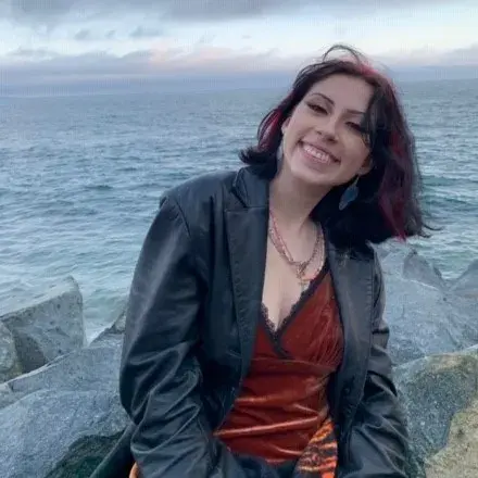 teen volunteer Sophia in front of the ocean at sunset