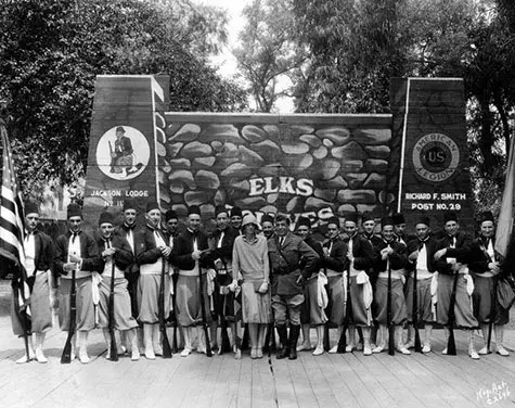 Group photo of Amelia Earhart with the Championship "Zouaves" Elks Drill Team from Jackson, Michigan, at the club during a Convention in 1929. Photo dated: March 17, 1930