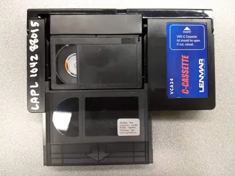 Photo of VHS-C inside adapter with lid open