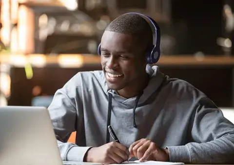 Man on laptop smiling.