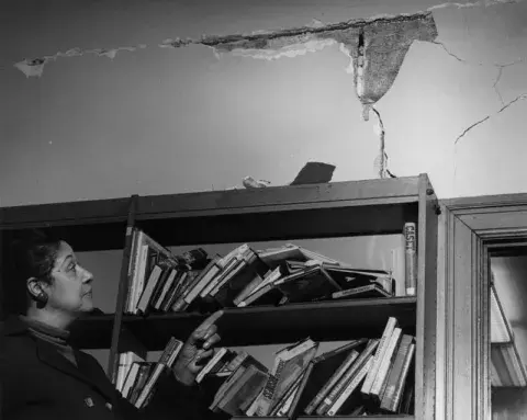 Commissioner King looks at crack in wall at Vernon Branch