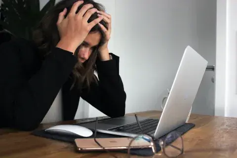 person upset looking at their laptop