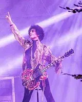 Prince in concert holding a guitar