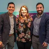2 men and a woman smiling with their arms around each other