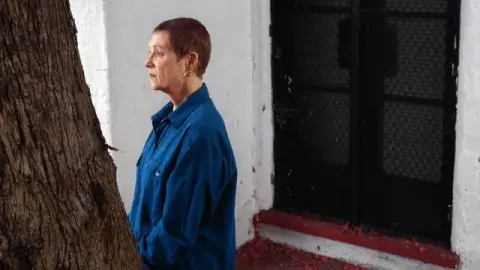 Holly Prado Northrup staring at a tree