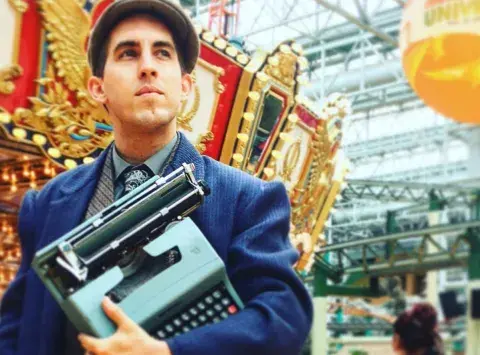 Brian Sonia-Wallace holding a typewriter