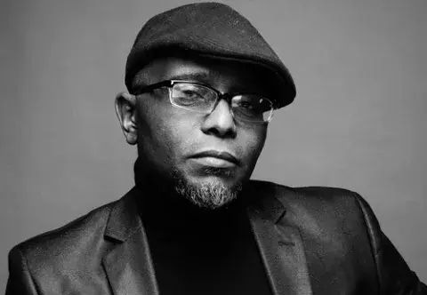 Tyehimba Jess in a jacket and cap. photo credit: John Midgley