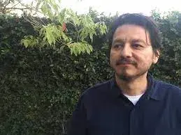 William Archila near a tall green shrub
