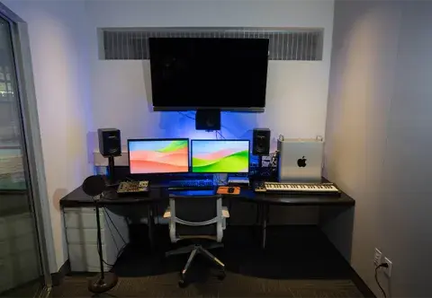 A studio space with two computer monitors and other equipment.