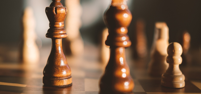 Wooden chess pieces on a chessboard.