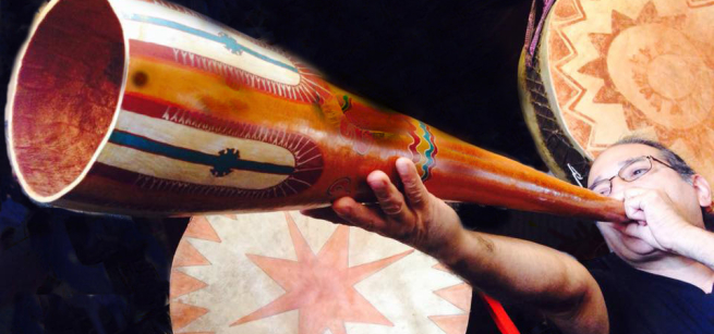 Christopher Garcia demonstrates a Mayan gourd trumpet known as hom-tah