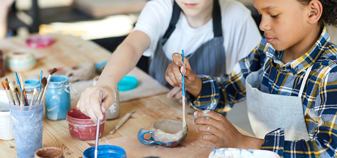 two kids painting ceramics