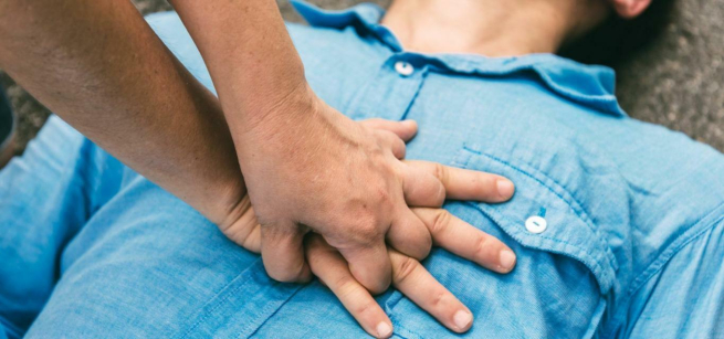 A person performing Hands-only CPR on a patient.