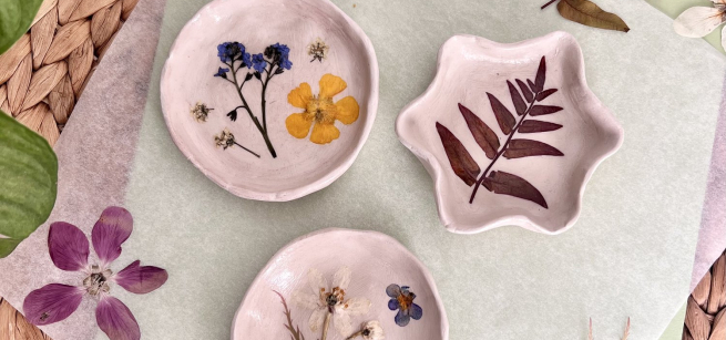 three clay dishes with flowers pressed into them.