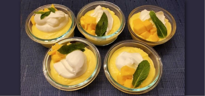 mango cream dessert garnished with whipped cream and fresh mint