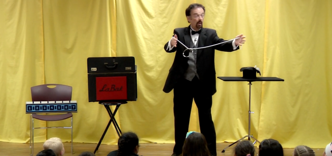 man in a suit doing magic tricks