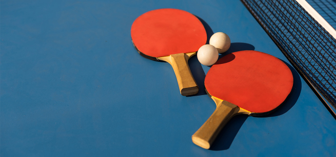 Close-up of ping pong paddles and balls on a game table