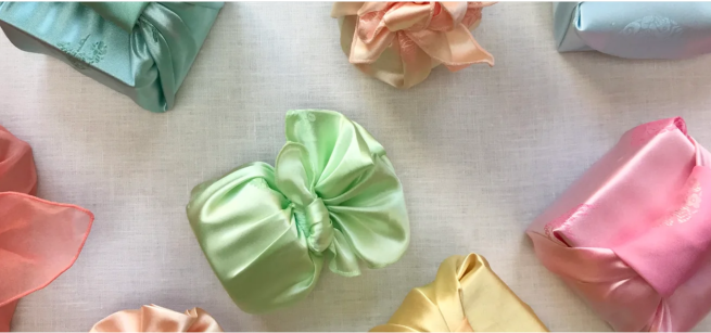 Bows of various colors are laid in front of a light background.
