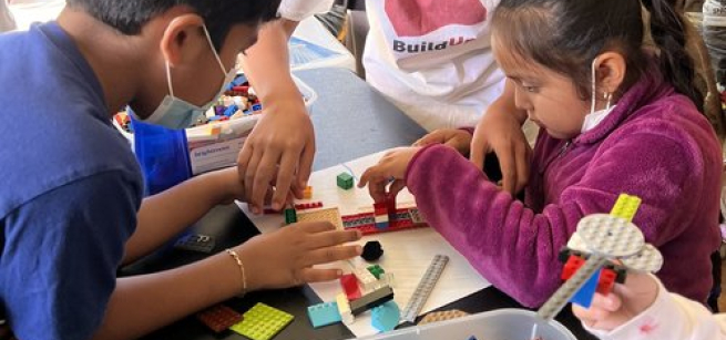 Three kids building with LEGOs.
