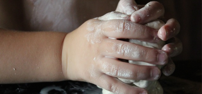 Child's hand holding clay